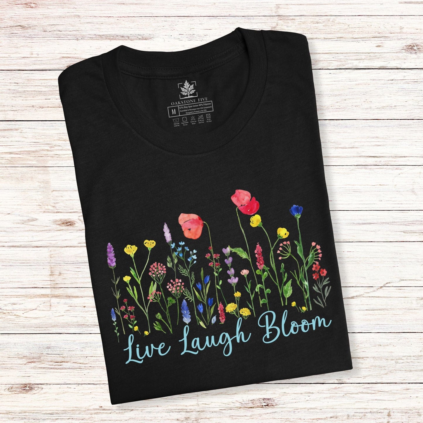 A cute, black, flower shirt for ladies that has bright, colorful flowers and says, Live Laugh Bloom."