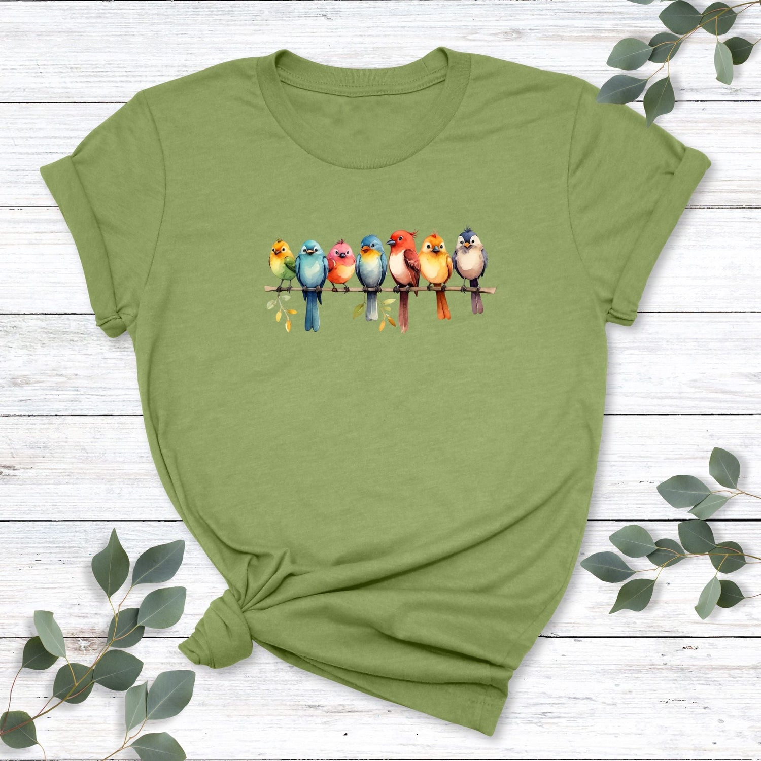 A cute nature t-shirt for bird lovers that has a design of a row of colorful birds sitting on a tree branch. 