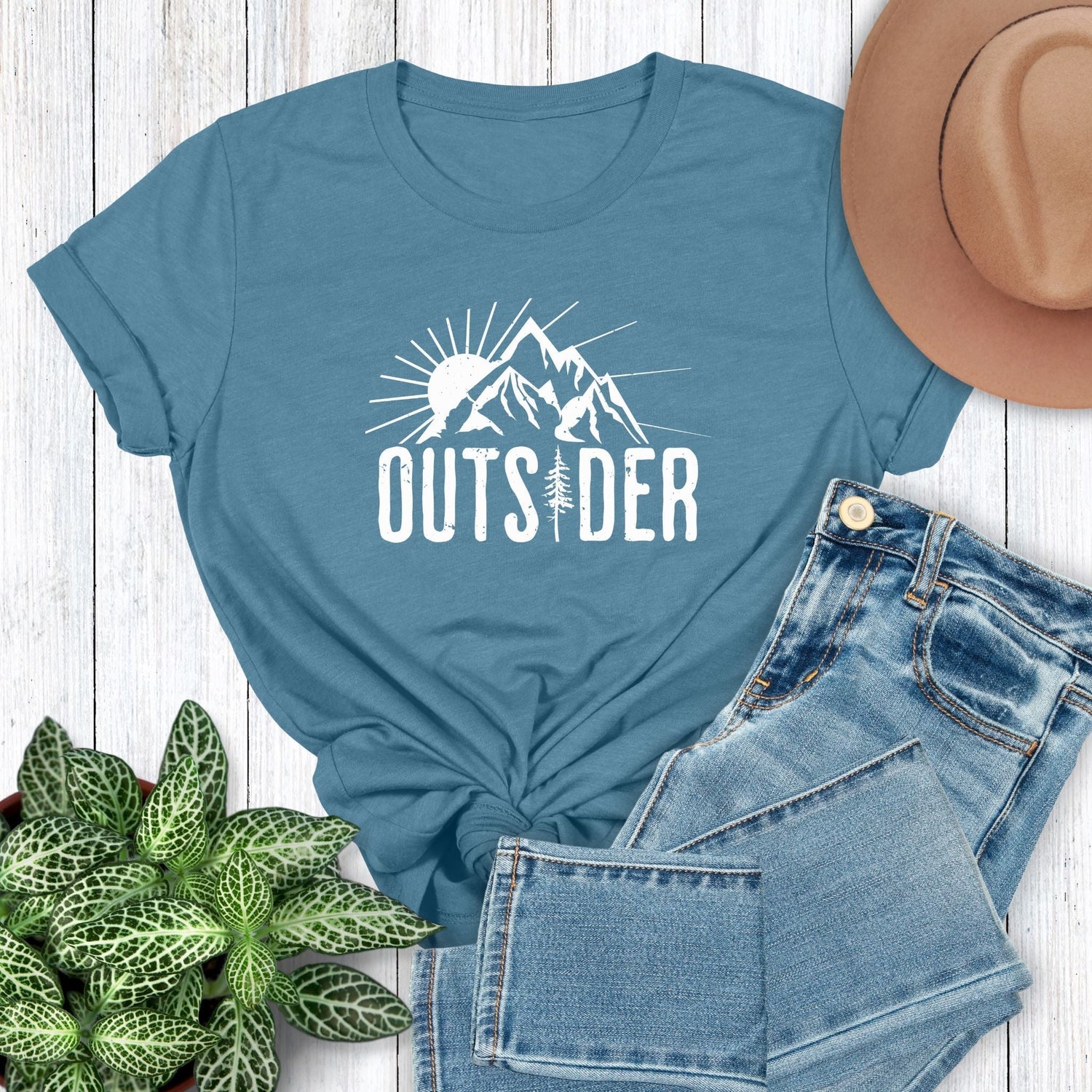 A nature t-shirt for outdoor lovers that has a print of a sun and mountain and says, Outsider.