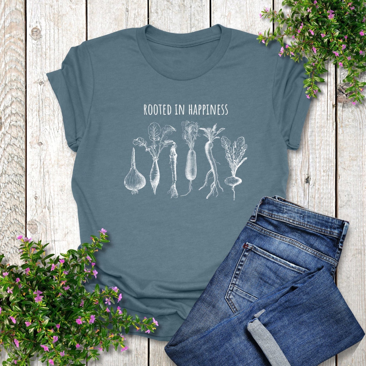 A cute, nature-themed t-shirt for gardeners that says, Rooted in Happiness, and has a design with root vegetables.