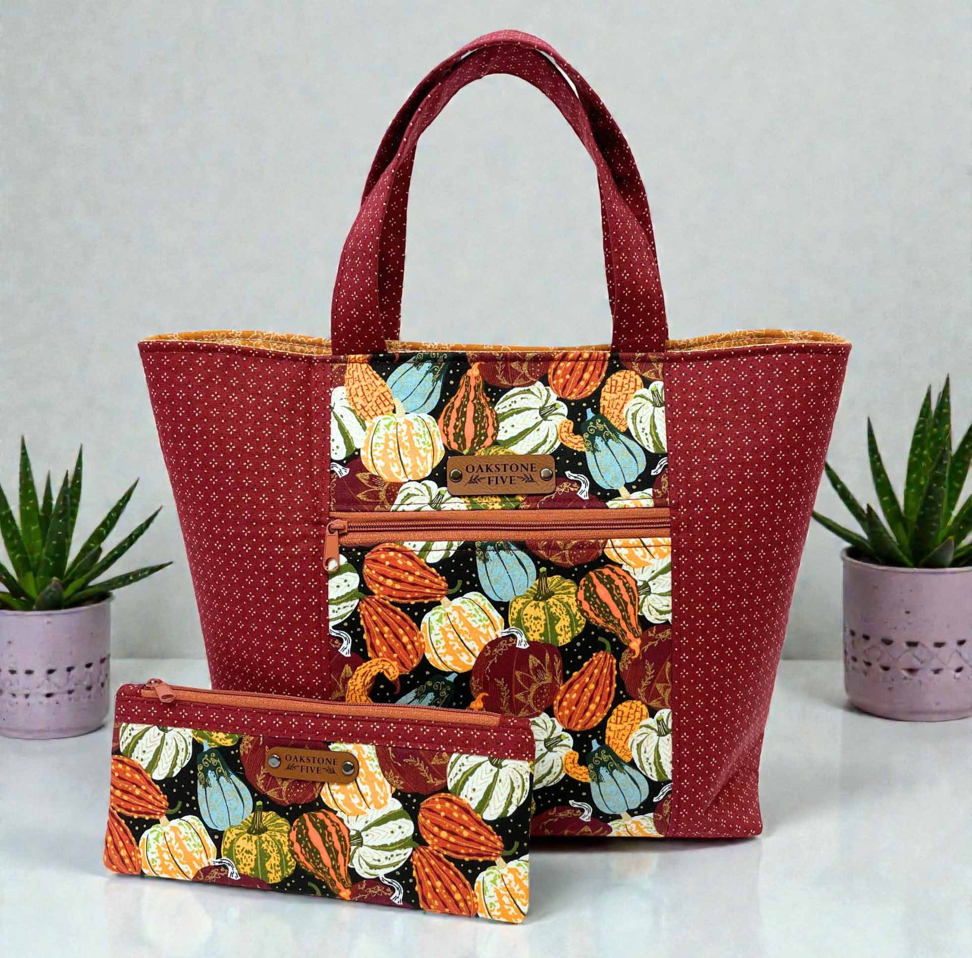 Tote bag with pumpkin pattern and matching zipper pouch on a light gray background