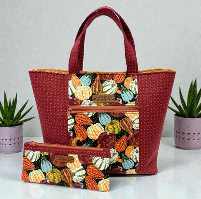 Tote bag with pumpkin pattern and matching zipper pouch on a light gray background