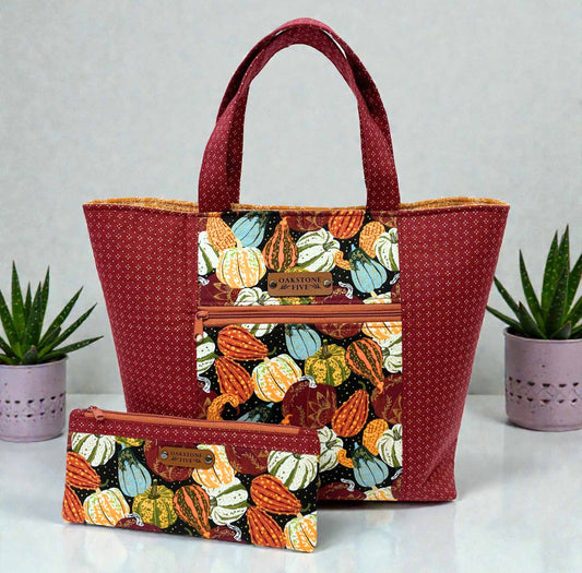 Tote bag with pumpkin pattern and matching zipper pouch on a light gray background