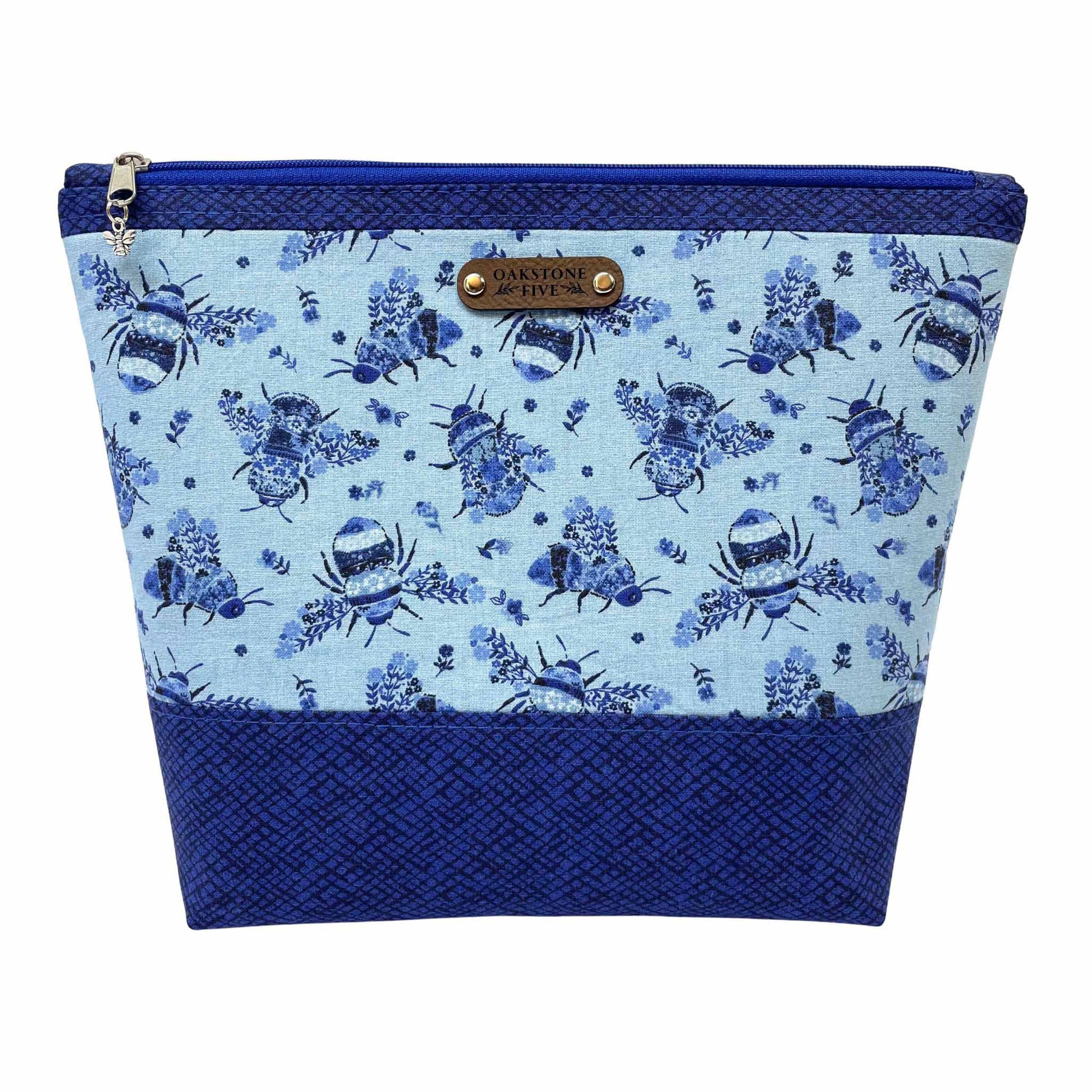 Blue floral bumble bee patterned zipper pouch with a white background