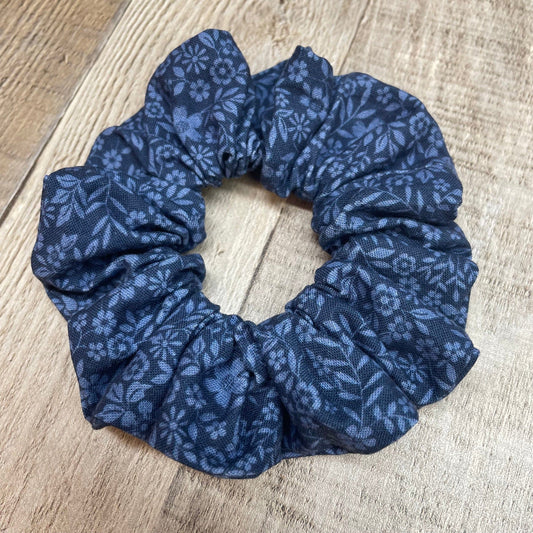 Blue floral patterned scrunchie on a wooden surface
