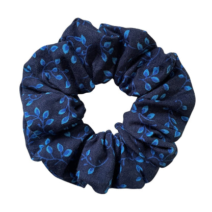 Navy blue scrunchie with blue leaf and vines pattern on a white background