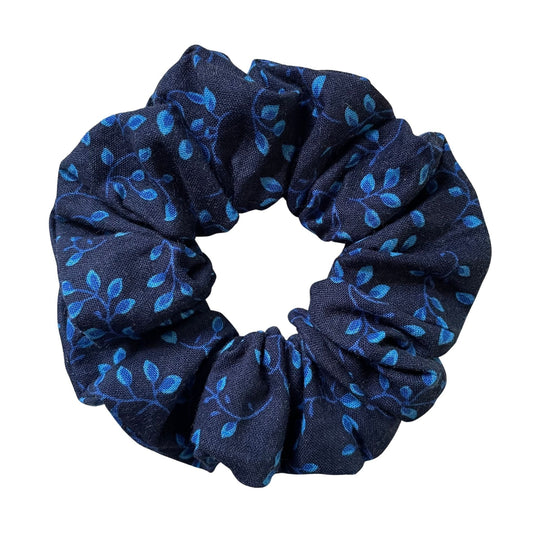 Navy blue scrunchie with blue leaf and vines pattern on a white background