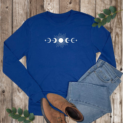 Blue long-sleeve shirt with moon phase design on a wooden surface with jeans and boots.