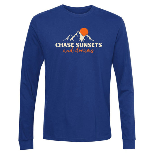 A royal blue, long-sleeve chasing sunsets shirt for nature lovers. Has an image of a mountain range and sun and says, "Chase Sunsets and Dreams."