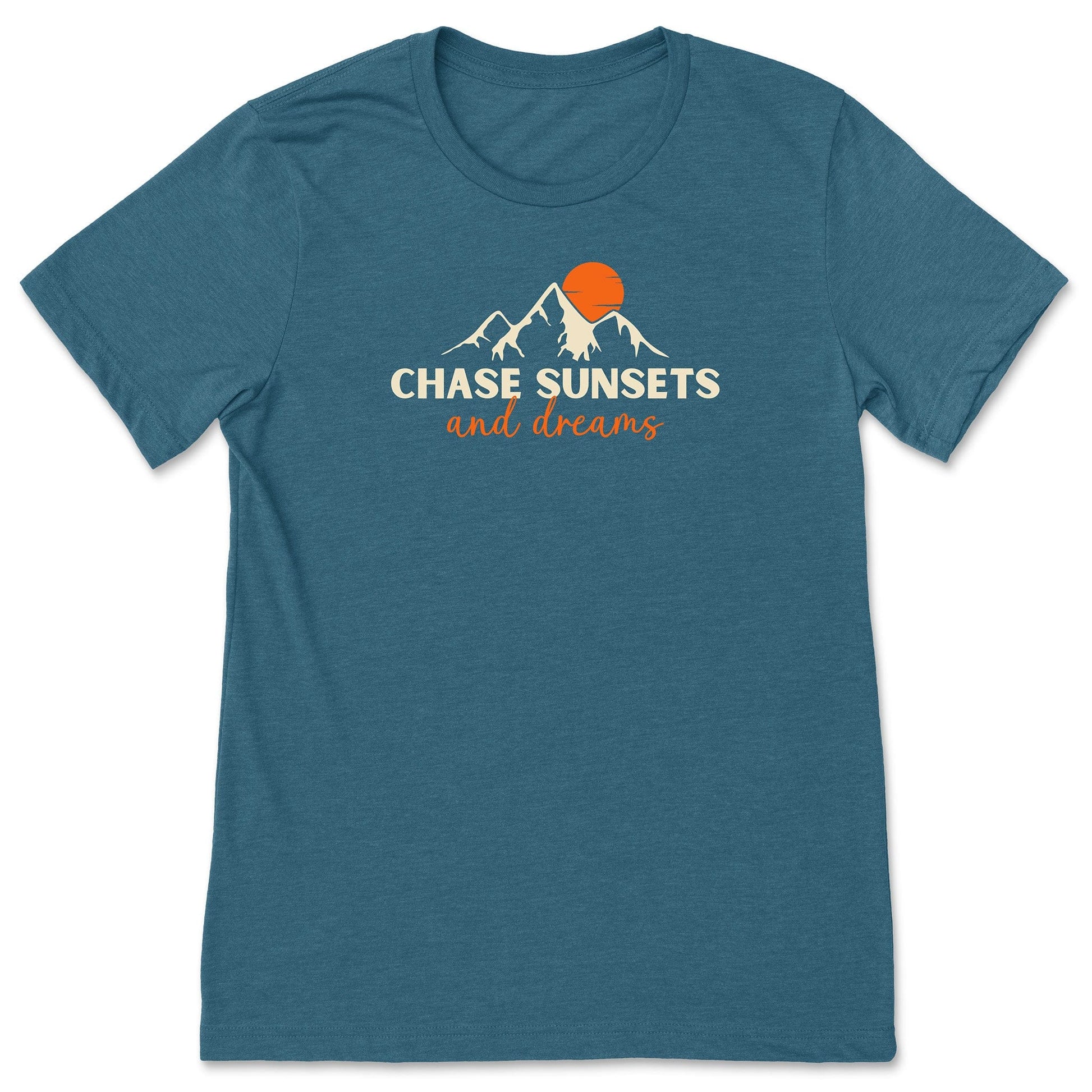 A teal chasing sunsets t-shirt that has mountains with an orange sunset and says, "Chase Sunsets and Dreams."