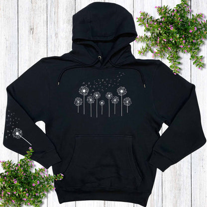 Navy hoodie with a dandelion design, on a wooden surface with potted flowers