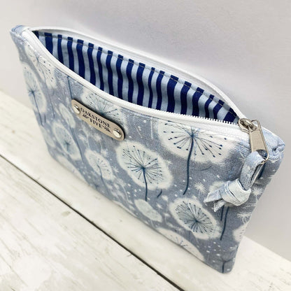 Fabric zipper pouch with dandelion pattern on a wooden surface