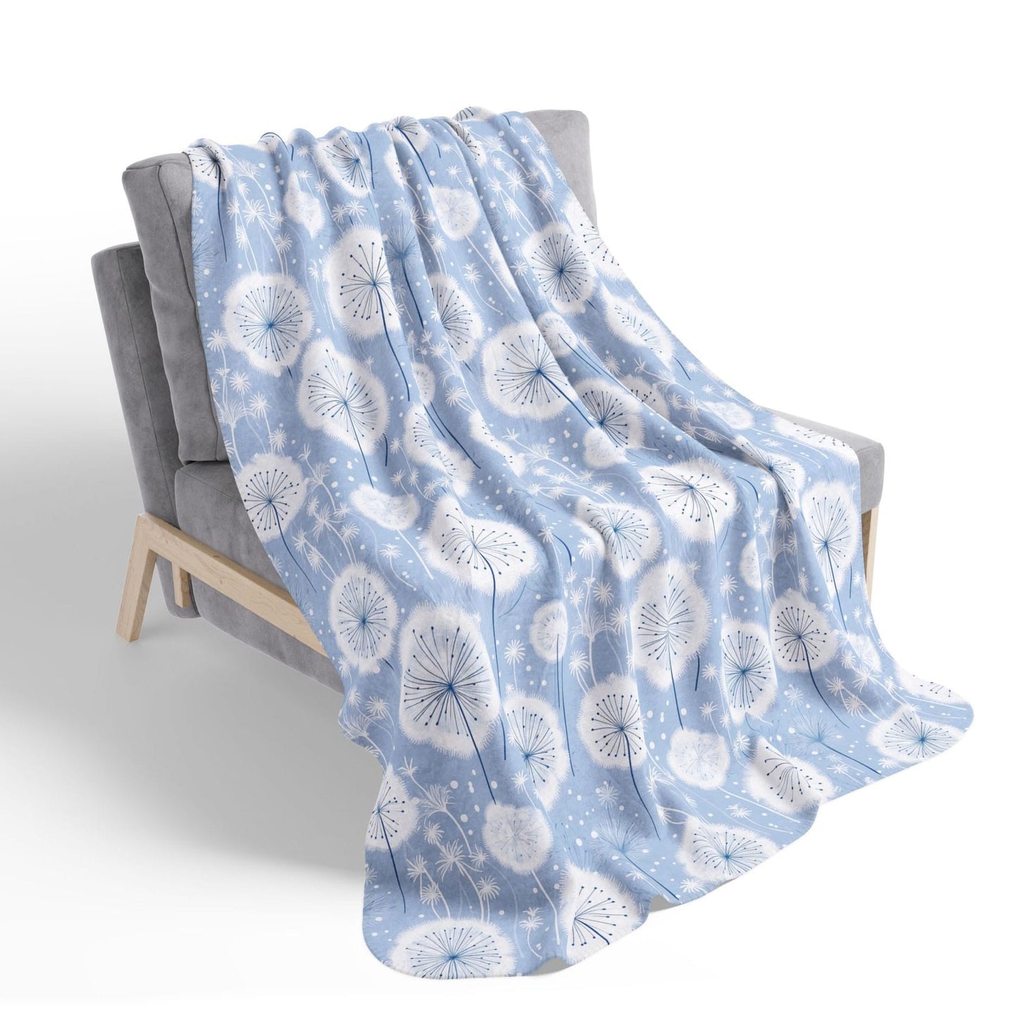 Blue blanket with white floral pattern draped over a chair on a white background