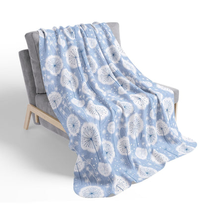 Blue blanket with white floral pattern draped over a chair on a white background