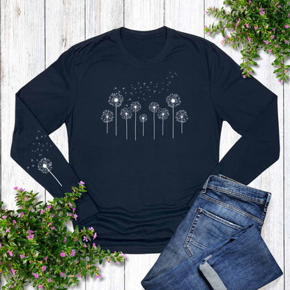 Navy long-sleeve shirt with dandelion design on a white wooden background with jeans and flowers.