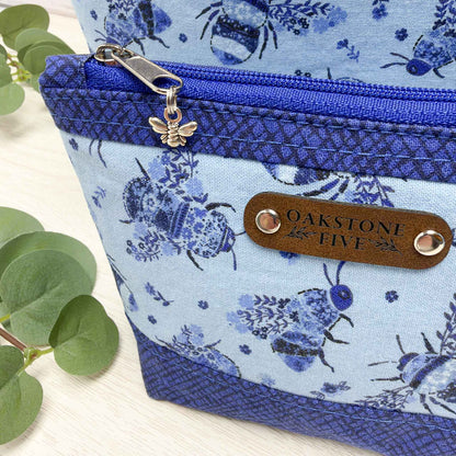 A close-up of a blue flowers and bees zipper pouch.
