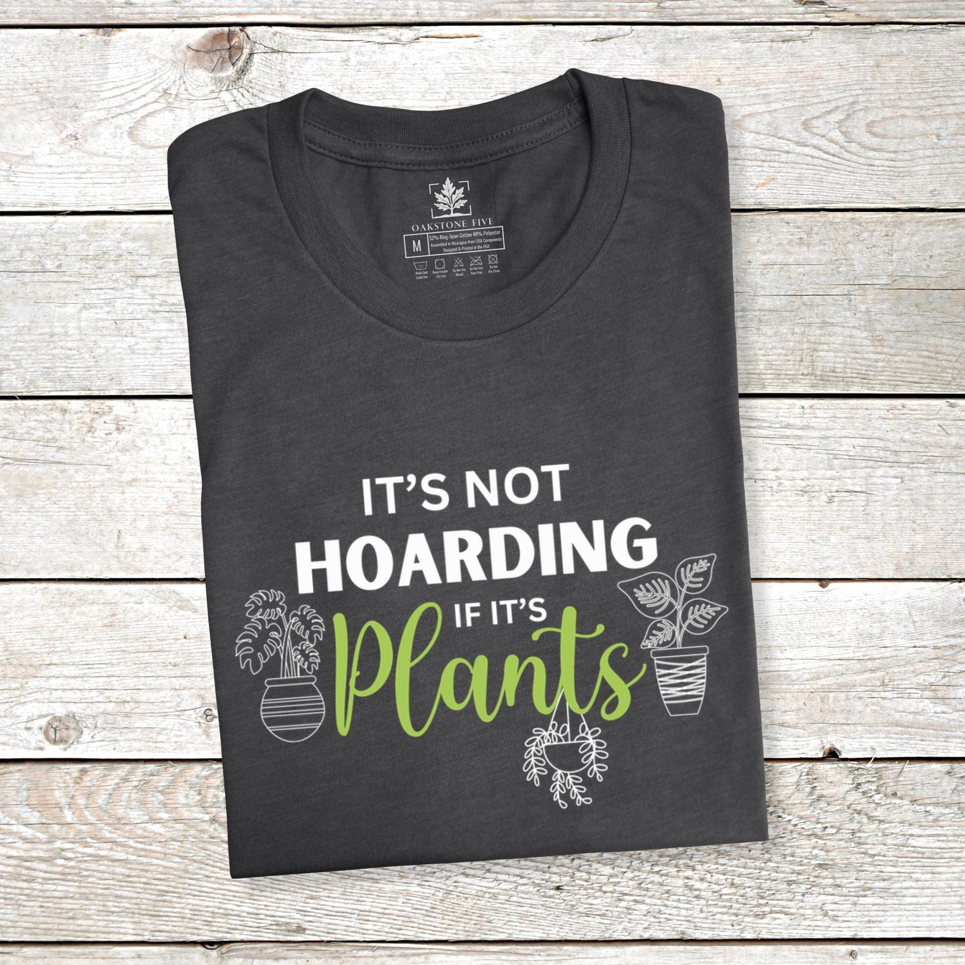 A folded grey funny plant t-shirt for gardeners that has potted plants and says, "It's not hoarding if it's plants".  A great gift idea for plant lovers!