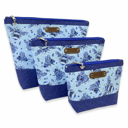 Three sizes of a blue floral zipper pouch with a bumble bee design on a white background