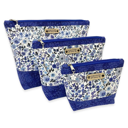 Set of three blue floral-patterned zipper pouches with blue accents on a white background