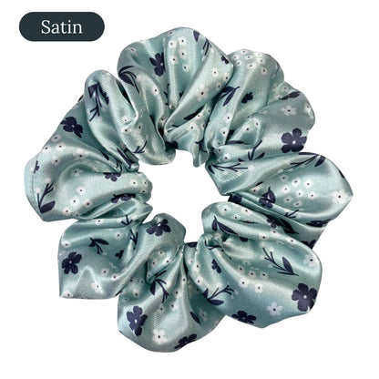 Light green satin scrunchie with floral pattern on a white background