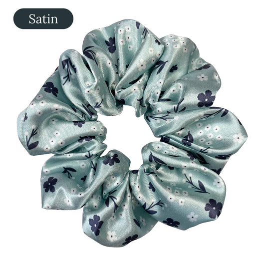 Light green satin scrunchie with floral pattern on a white background