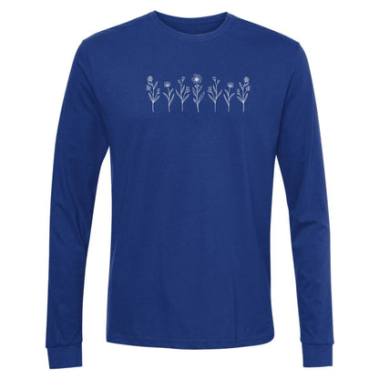 A cute, royal blue, long-sleeve wildflower t-shirt for nature and plant lovers that has a design on across the chest of several small white wildflowers in a  row.