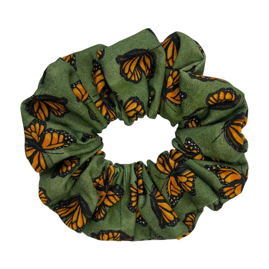 Green hair scrunchie with orange and black monarch butterfly pattern on a white background.