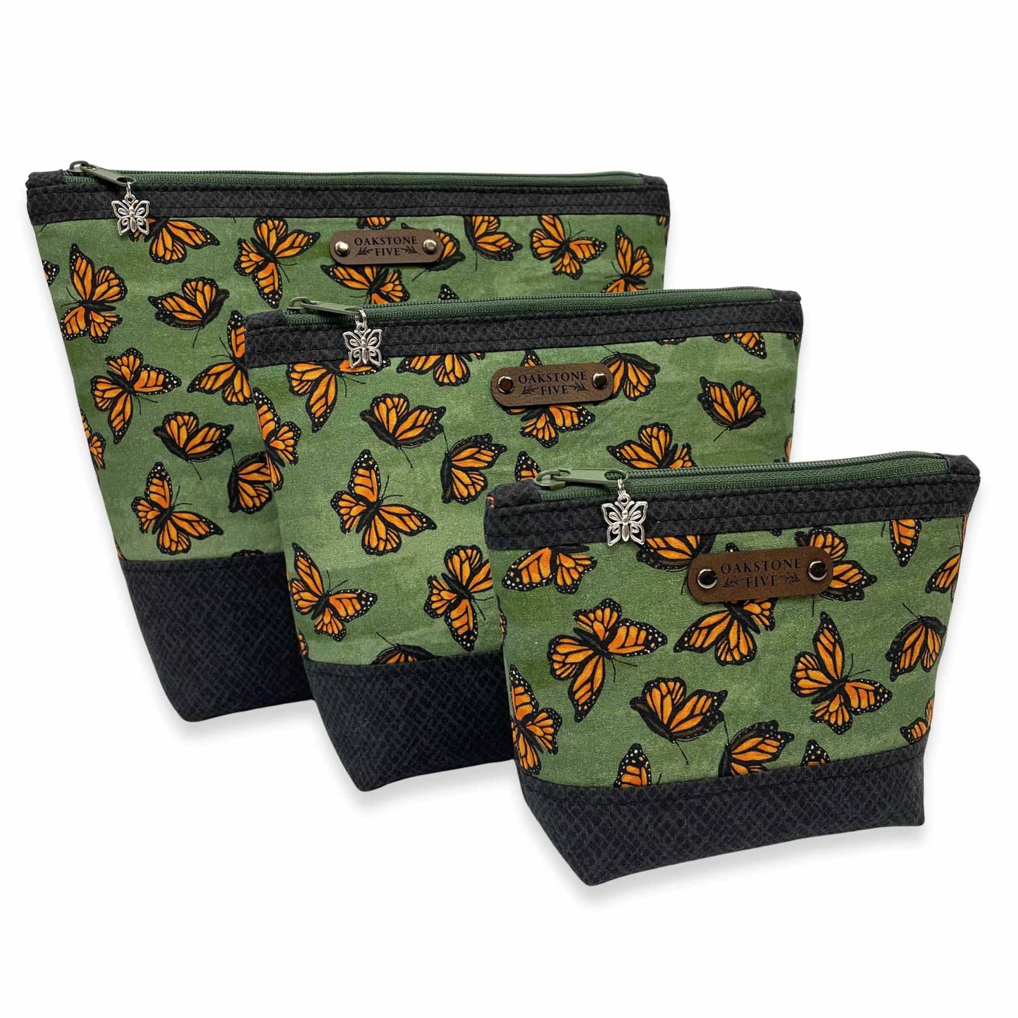 Three green zipper pouches with monarch butterfly pattern on a white background