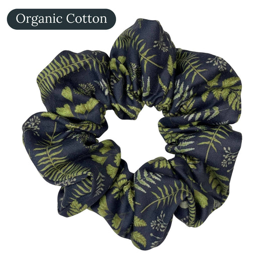 Navy blue organic cotton scrunchie with green leaf and fern pattern on a white background