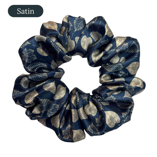 Navy blue satin scrunchie with leaf pattern on a white background