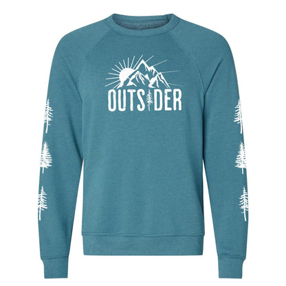 A teal, ultra-soft raglan sweatshirt for nature lovers and outdoor enthusiasts that has a sun behind a mountain and says, "Outsider", and has trees down both sleeves. 
