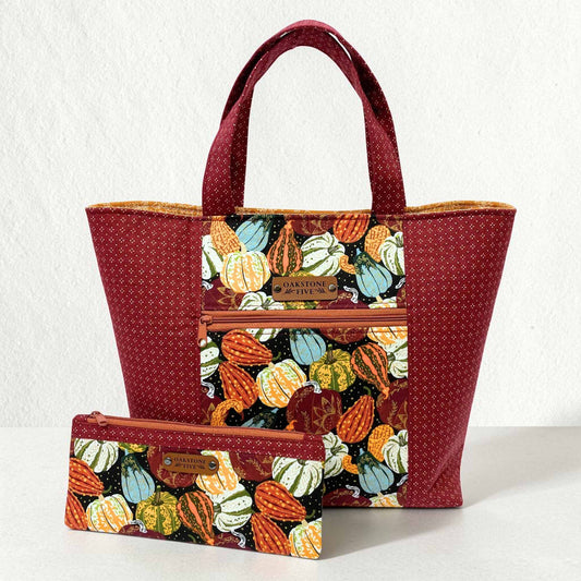 Tote bag with a fall pumpkin and gourd pattern with a matching zipper pouch, on a light gray background