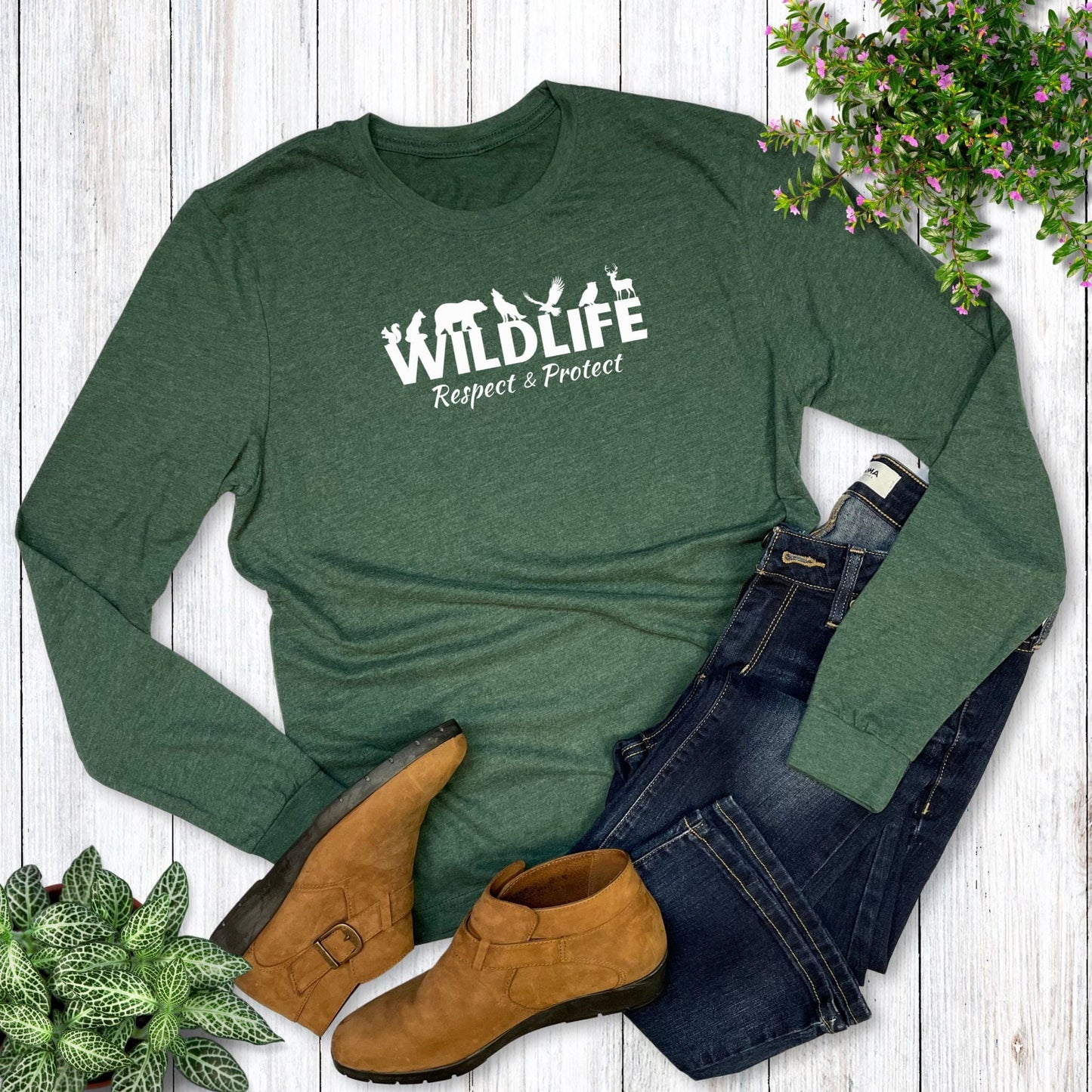 Green long-sleeve shirt with 'Wildlife Respect & Protect' text, paired with jeans and boots on a wooden surface.