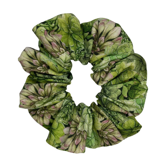 A green, handmade scrunchie with a succulent pattern for plant lovers.