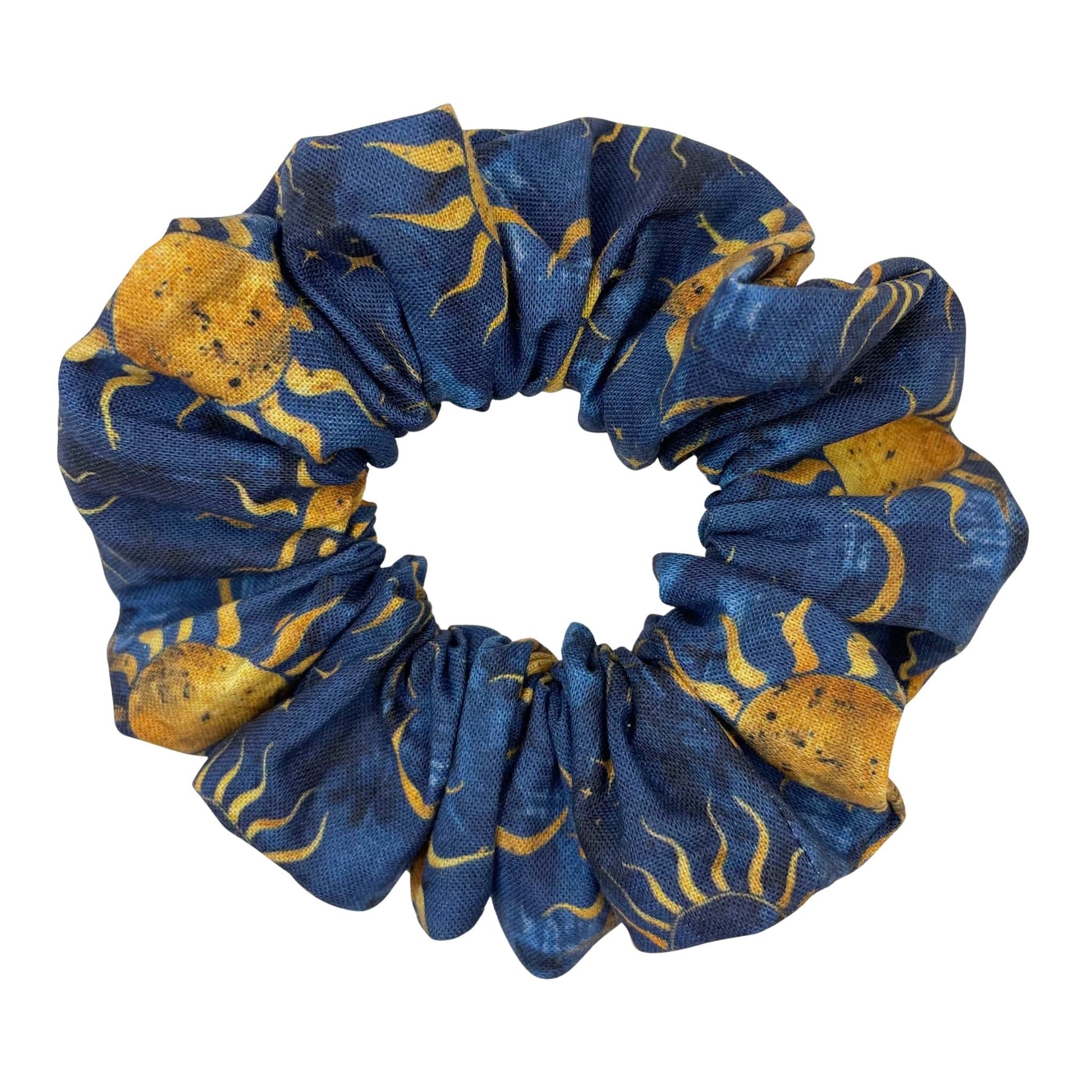 A blue, handmade scrunchie with a sun, moon, and stars pattern.