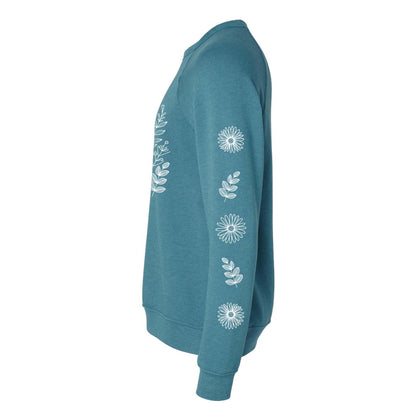 Side view of a teal sweatshirt with white floral patterns on the front and on both sleeves, on a white background